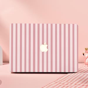 Könnte beinhalten: Ein Laptop mit rosa und weißen Streifen und dem Apple-Logo in der Mitte. Der Laptop steht auf einer rosa Oberfläche. Der Hintergrund ist einfarbig rosa.