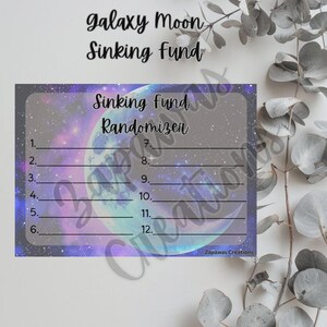 May include: A galaxy-themed Sinking Fund Randomizer card with a purple and blue space background. The card features a large moon graphic and numbered lines for tracking savings goals. Text at the top reads "Galaxy Moon Sinking Fund."