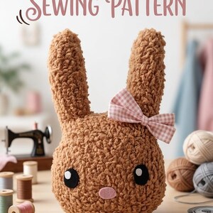May include: A plush bunny sewing pattern. The brown bunny has large ears and a pink gingham bow. The bunny has black eyes and a pink nose. The words "Bunny Plush Sewing Pattern" are at the top of the image. A PDF download icon is in the bottom right corner.