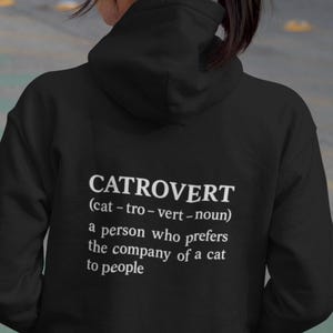 May include: Black hooded sweatshirt with the word "CATROVERT" printed in white, along with a definition: "a person who prefers the company of a cat to people."