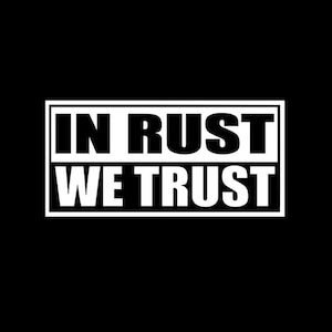 May include: Black background with the white text "IN RUST WE TRUST" inside a white rectangular border. The text is in a bold, sans-serif font.