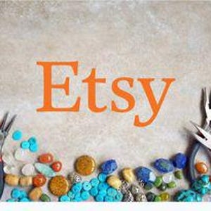 Puede incluir: La palabra "Etsy" en letras naranjas est&aacute; centrada en una superficie marr&oacute;n claro. Varias herramientas para hacer joyas y cuentas coloridas, incluyendo turquesa, naranja y azul, est&aacute;n dispuestas alrededor del texto.