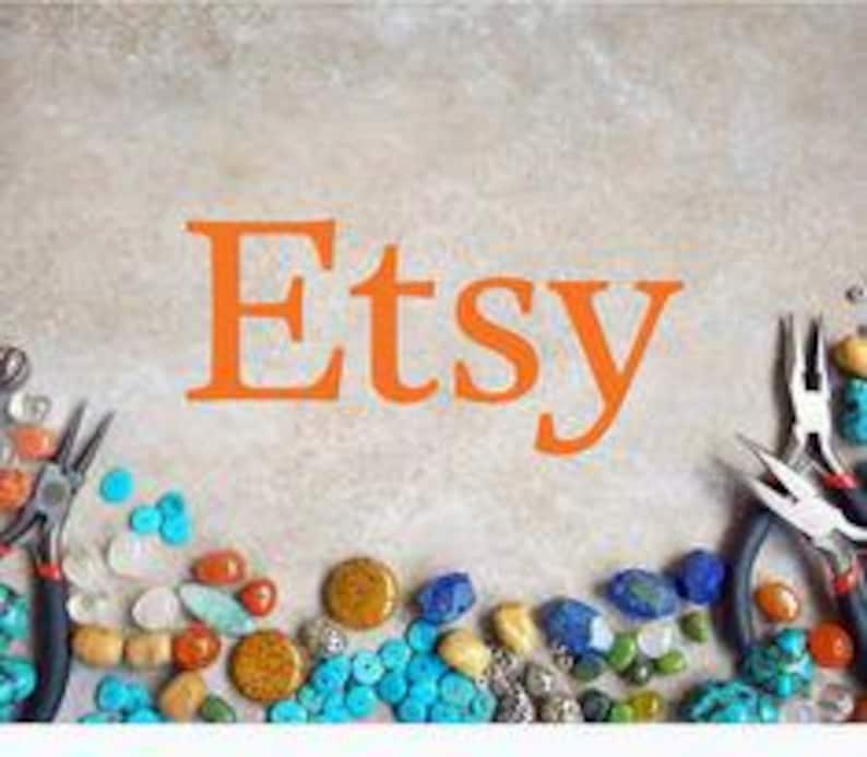 Puede incluir: La palabra "Etsy" en letras naranjas est&aacute; centrada en una superficie marr&oacute;n claro. Varias herramientas para hacer joyas y cuentas coloridas, incluyendo turquesa, naranja y azul, est&aacute;n dispuestas alrededor del texto.