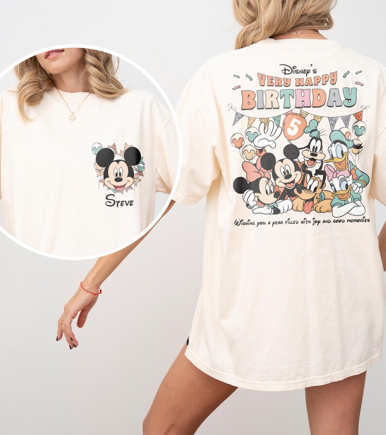Puede incluir: Camiseta color crema con un gr&aacute;fico de Mickey Mouse en la parte delantera y el nombre "Steve". La parte trasera de la camiseta muestra un colorido dise&ntilde;o de cumplea&ntilde;os de Disney con Mickey, Minnie, Donald, Goofy y Daisy. El texto dice "Very Happy Birthday" y "Wishing you a year filled with joy and good memories."