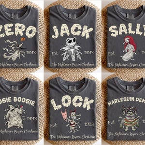 Op de afbeelding: Zes antracietgrijze t-shirts met personages uit "The Nightmare Before Christmas". Elk shirt toont de naam van een personage in een gestileerd lettertype, samen met een illustratie en de tekst "Est. 1993 The Nightmare Before Christmas."