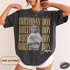Puede incluir: Una camiseta de manga corta gris carbón con el texto dorado repetido "BIRTHDAY BOY" en disposición vertical. El centro muestra una fotografía en blanco y negro de un niño pequeño con una sudadera con el texto "ATHLETIC DEPT" y el nombre "Jasper" en letra blanca.