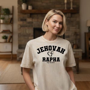 La camiseta de Jehová Rapha representa al Señor que sana. Una reconfortante camiseta cristiana que celebra el poder sanador de Dios.