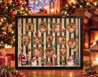 Könnte beinhalten: Ein rechteckiger Schattenkasten mit grün-weiß gestreiftem Hintergrund und mehreren verzierten goldenen Bilderrahmen mit Fotos. Die Dekoration enthält Miniaturfiguren von Weihnachtsmann, Schneemännern und Elfen.