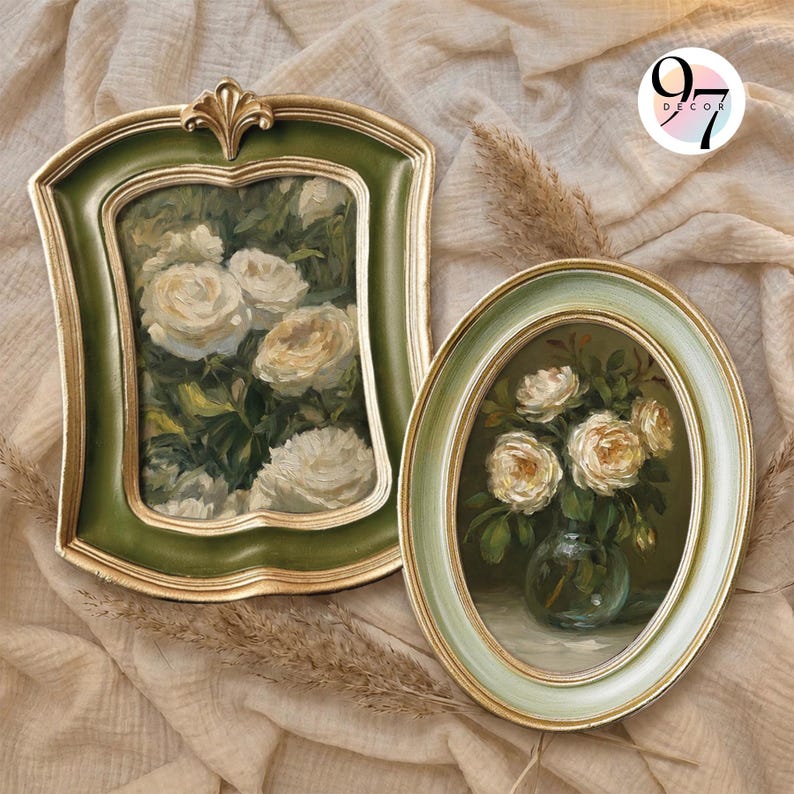 May include: Two framed paintings featuring white roses. The left frame is rectangular with a green and gold finish. The right frame is oval with a light green and gold finish. The paintings depict floral arrangements. A logo reads 97 DECOR.