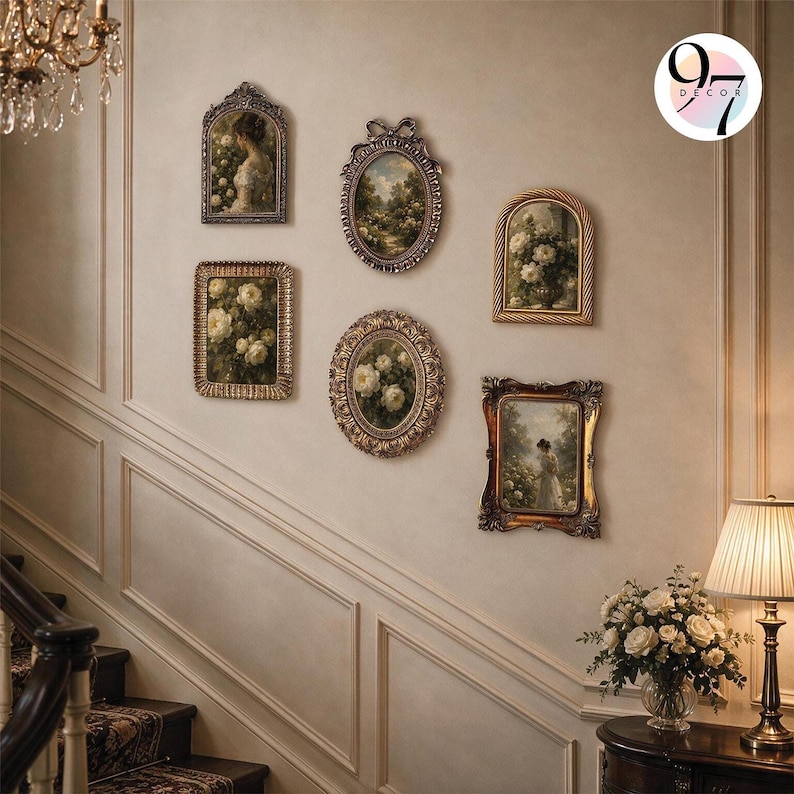 Six vintage-style ornate picture frames arranged symmetrically on a staircase wall next to a lit lamp.