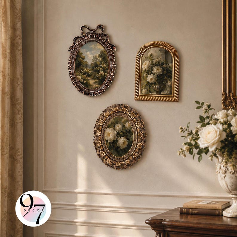 Three ornate picture frames with classical paintings hanging on a beige wall above a wooden table.