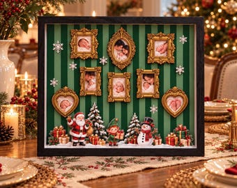 Könnte beinhalten: Ein schwarzer Schattenkasten-Rahmen mit einem grün und dunkelgrün gestreiften Hintergrund und sieben verzierten goldenen Bilderrahmen mit Babyfotos. Das Display enthält Miniaturfiguren von Weihnachtsmann, Elf, Schneemann und Geschenken, akzentuiert durch weiße Schneeflocken.