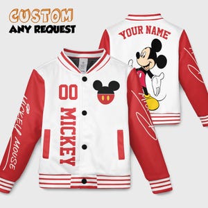 May include: A white and red varsity jacket with a Mickey Mouse theme. The jacket features red sleeves with "Mickey Mouse" printed on one sleeve and a Mickey Mouse head logo on the chest. The back of the jacket has a Mickey Mouse graphic and the text "YOUR NAME".