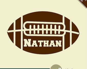 May include: Brown football-shaped wall decal with the name "NATHAN" in white lettering. The decal is designed to look like a football with white stitching.