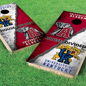 May include: Two wooden cornhole boards with a distressed white and red paint design. The boards are divided in half, with the top half featuring the University of Alabama logo and the bottom half featuring the University of Kentucky logo. The text "House Divided" is printed on both boards.