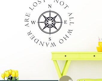 Puede incluir: Una brújula en blanco y negro con el texto "Are lost not all who wander" alrededor de la brújula. La brújula tiene las letras N, S, E y W para los puntos cardinales.