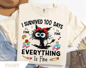 May include: Ivory-colored t-shirt with a distressed graphic of a black cat wearing a red polka-dot headband. The text reads "I Survived 100 Days Everything Is Fine." Additional graphics include books, a paintbrush, and a pencil.
