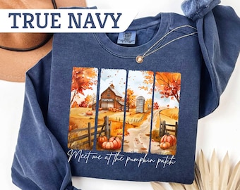 May include: True navy blue sweatshirt with a fall-themed graphic. The graphic features a barn, pumpkins, and the text "Meet me at the pumpkin patch." The sweatshirt has a crew neck and long sleeves.
