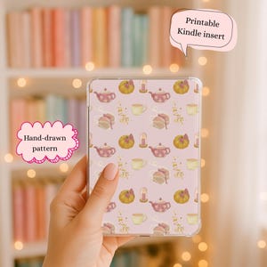 May include: A clear Kindle case with a hand-drawn pattern of teapots, pumpkins, teacups, and cake slices on a pink background. The case has the text "Printable Kindle insert".