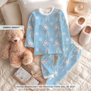 Può includere: Pigiama azzurro con un motivo ripetuto di volpi artiche bianche, fiocchi di neve e alberi. La maglia a maniche lunghe e i pantaloni sono esposti con un orsacchiotto e pantofole soffici. Il testo "EXAMPLE PRODUCT" è visibile.