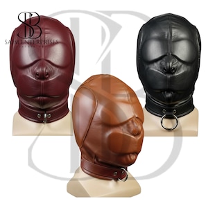 May include: Three leather hoods in burgundy, brown, and black, each featuring a dog-like snout design. Each hood has a collar with a metal ring. The logo "SAIM ENTERPRISES LEATHER ART" is visible in the upper left corner.