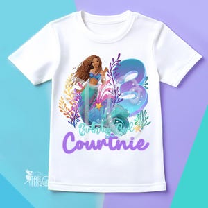 May include: White t-shirt with a mermaid design, the number 3, the name "Courtinie", and the words "Birthday Girl". The mermaid has brown hair and wears a blue top and a teal tail.