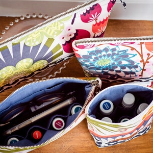 May include: Four zippered pouches with floral patterns. The pouches are open to reveal a blue lining and various items, including glasses, pens, and small bottles.