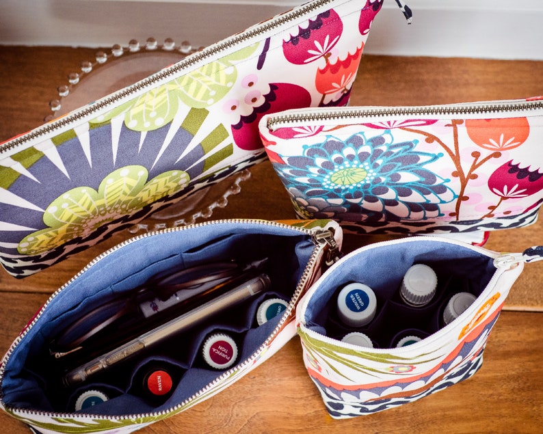 May include: Four zippered pouches with floral patterns. The pouches are open to reveal a blue lining and various items, including glasses, pens, and small bottles.