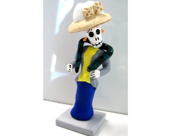 Figurine miniature vintage représentant une femme squelette et serpent, inspirée de l'art populaire mexicain du Jour des Morts.