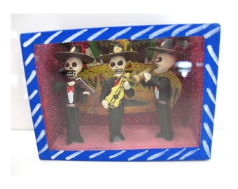 Diorama vintage en verre nicho représentant un groupe de mariachis squelettes sur le thème du Jour des Morts. Art populaire mexicain.