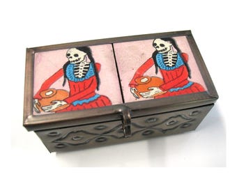 Boîte à bijoux vintage en métal gaufré et carreau représentant une dame squelette sur le thème du Jour des Morts