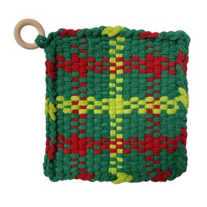 May include: A square, woven hot pad in green, red, and yellow. The design features a plaid pattern with a wooden ring attached for hanging. The edges are finished with a green border.