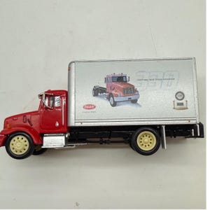 May include: A red and silver Peterbilt 330 model truck with a box trailer. The side of the silver trailer features a graphic of a red truck, the text 330, the Peterbilt logo, and the words Class Pays and Exceptional Value, Highest Satisfaction.