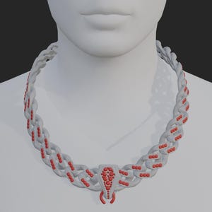 Pode incluir: Um colar branco com detalhes vermelhos é exibido em um manequim. O colar apresenta um design semelhante a uma corrente com contas vermelhas e um pingente central. O pingente tem um design vermelho e um elemento em forma de gancho.