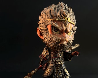 May include: A detailed figurine of a monkey-like warrior with a fierce expression. The figure is adorned in ornate armor with gold and red accents, holding a staff. The base is dark brown, and the background is black.