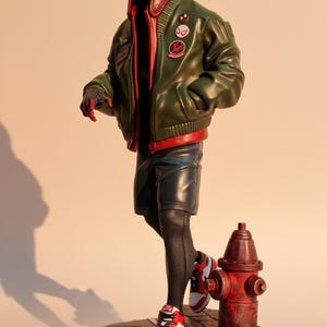 May include: A detailed figurine of a superhero in a green bomber jacket, red hoodie, and black shorts. The figure is wearing red and white sneakers and stands on a base with a fire hydrant. The figure has a mask with red lenses.