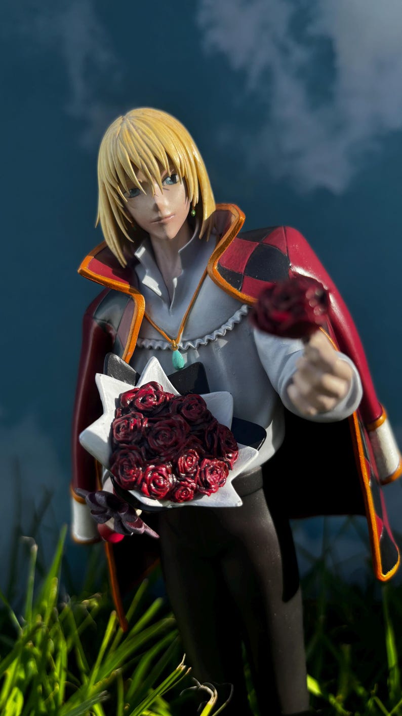 K&ouml;nnte beinhalten: Figur eines Charakters mit blonden Haaren, der einen roten und schwarzen Umhang tr&auml;gt und einen Strau&szlig; roter Rosen h&auml;lt. Die Figur ist vor einem blauen Himmelshintergrund mit gr&uuml;nem Gras im Vordergrund platziert.