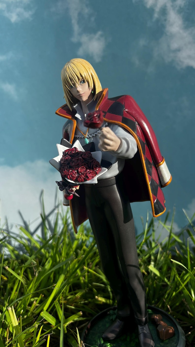 K&ouml;nnte beinhalten: Figur eines Charakters mit blonden Haaren, der einen rot-schwarzen Umhang tr&auml;gt und einen Strau&szlig; roter Rosen h&auml;lt. Die Figur steht in einem grasbewachsenen Bereich mit blauem Himmel im Hintergrund.