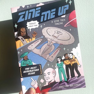 May include: A comic book cover featuring a colourful illustration of a spaceship, characters, and the text "Zine Me Up: A Star Trek Fanzine". The text "The Next Generation Issue" is also included on the cover.