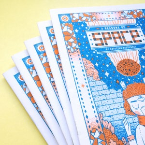 May include: A stack of five blue and orange illustrated zines titled "A Measure of Space" by Kristina Baczynski.