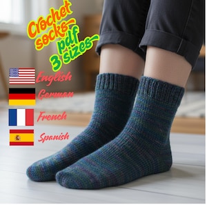 May include: A pair of hand-knitted blue and green socks. The socks are displayed on a person's legs. Text in the image reads "Crochet socks pdf 3 sizes". Flags of the United States, Germany, France, and Spain are also visible.