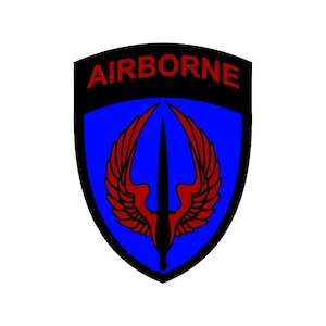 May include: A shield-shaped emblem with a blue background and a black border. The word "AIRBORNE" is in red at the top. A red and black design of a winged dagger is in the center.
