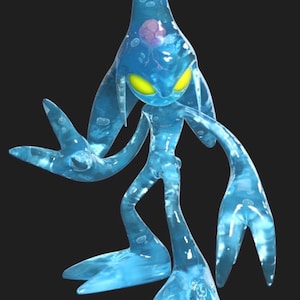 May include: A translucent blue character with a teardrop-shaped head, yellow eyes, and elongated limbs. The character has a fluid appearance, with bubbles and a pinkish-purple orb visible within its form. The figure stands against a black background.