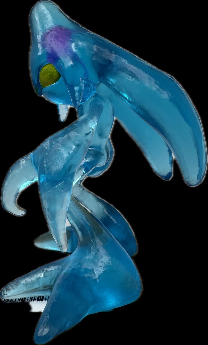 May include: A translucent blue figure with a flowing, amorphous form. The figure has a large head with a yellow eye and a purple marking. Its limbs are elongated and fluid, suggesting movement. The overall design evokes a sense of ethereal beauty.