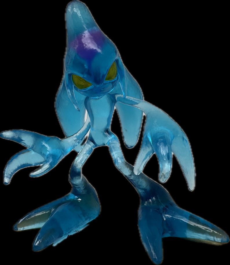 May include: A translucent blue figurine of a creature with a teardrop-shaped head, yellow eyes, and elongated limbs. The figure has a purple area on its head and is posed against a black background. The overall design suggests a fantasy or video game character.