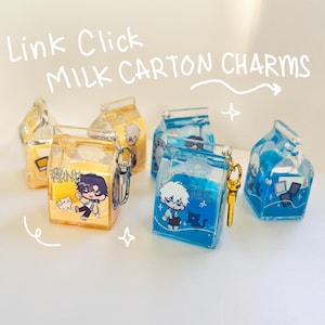 May include: Clear acrylic milk carton charms with anime-style character illustrations in yellow and blue. Each charm has a gold-colored keychain attachment. Text on the charms reads "Link Click MILK CARTON CHARMS".