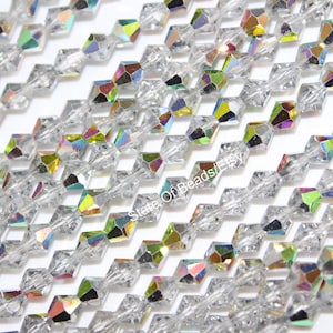 May include: Close-up of clear, faceted crystal beads with iridescent rainbow reflections. The beads are strung together in rows, creating a shimmering effect. Ideal for jewelry making and crafting.