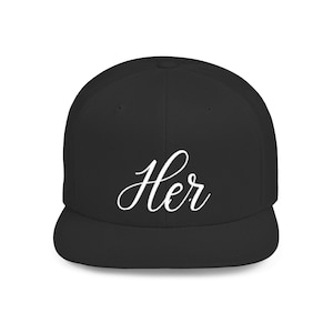 May include: A black baseball cap with a flat brim. The word "Her" is written in a white, cursive script across the front of the cap. The cap is a classic, unisex style.