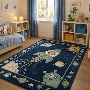 May include: A navy blue area rug with a space theme, featuring a large rocket ship, planets, stars, and a friendly alien. The rug is bordered with stars and planets, creating a fun and colorful design for a child's room.