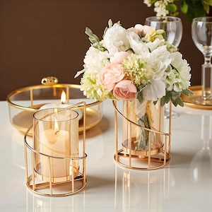 Puede incluir: Candelabros de metal dorado con diseño en espiral. Uno sostiene una vela encendida, otro un ramo de flores blancas y rosas. Una bandeja redonda de vidrio con una vela está en el fondo. Decoración del hogar.